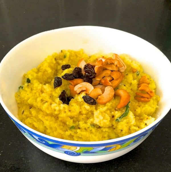 970x978_Ven Pongal Ven Pongal the delicious tamil version of khichdi. Garnished with fried cashew nuts and raisins, rice and moong dal lentils cooked together with turmeric, served in a white bowl patterned with blue and yellow