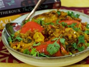 A plate of stuffed Shimla Mirch or stuffed capsicum with a brass spoon stuck in on the side