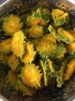 Round slices of bitter gourd or karela, marinated with turmeric and salt