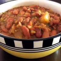 Red kidey beans cooked with spices into Rajma Masala, a winter dish in India. In a yellow bowl edged with black and white checks