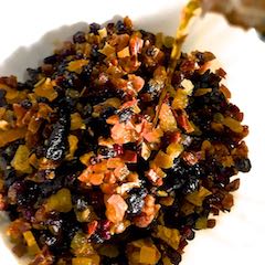 Pouring rum/ alcohol on fruits prepared and sliced, for soaking and adding to a Christmas Fruit Cake