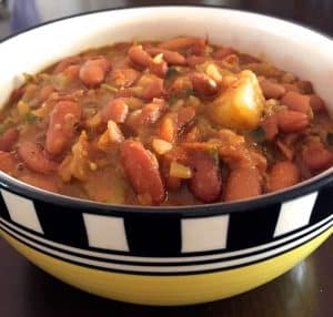 Nutritious tasty Rajma Masala Curry -spiced red kidney beans in tomato onion gravy in a yellow bowl with a black and white checked border