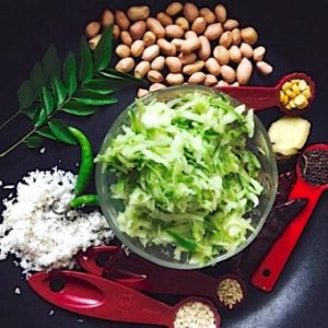 Ingredients in small bowls and spoons, for Raw mango rice: Peanuts, curry leaves, grated mango, grated coconut, mustard seeds, bengal gram, black gram, asafoetida powder, minced ginger