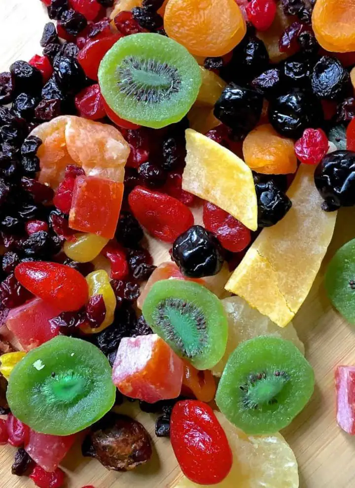 A colourful array of dry fruits, kiwi, pineapple, berries, citrus, papaya ready to be cut to soak fruits for Christmas cake