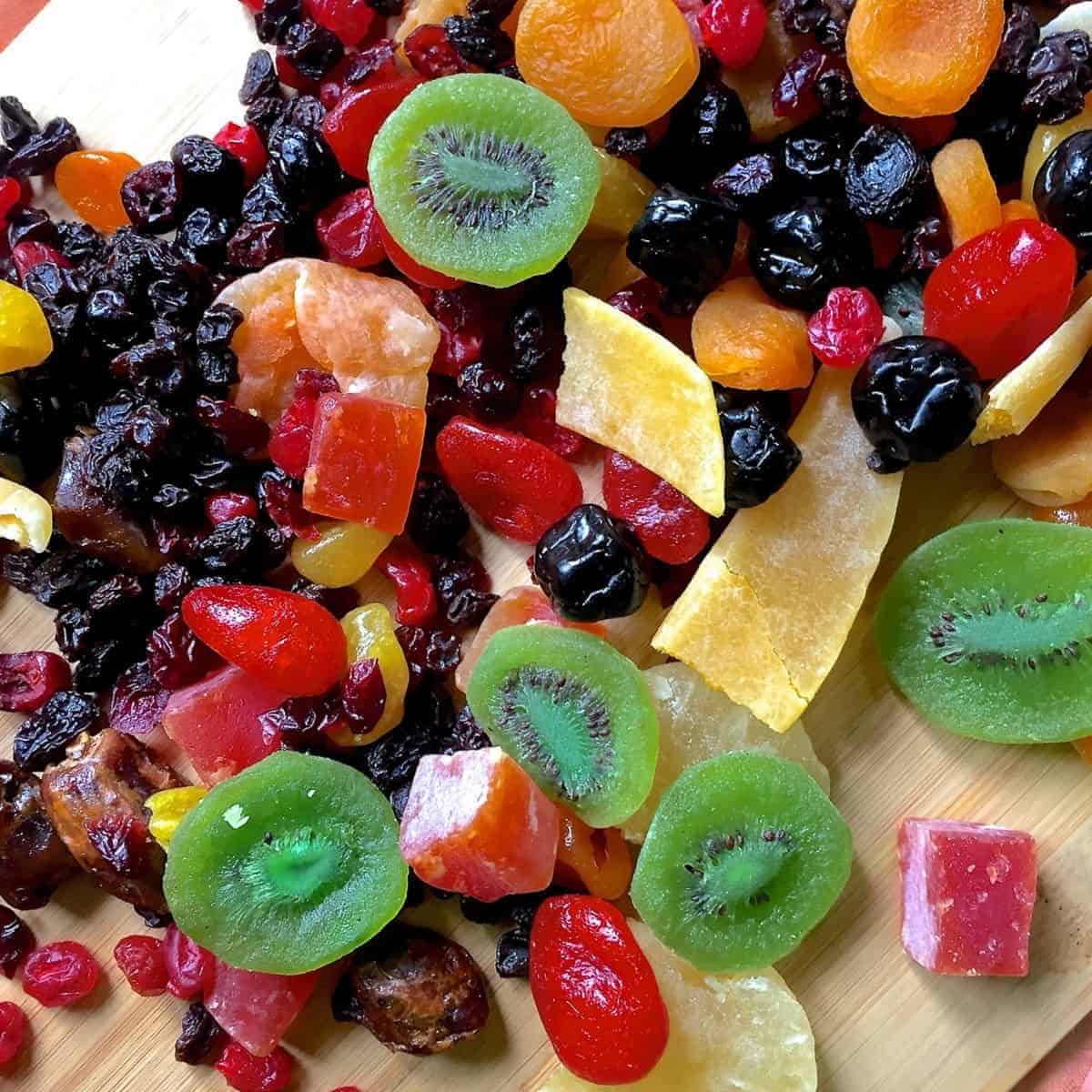A colourful array of dry fruits, kiwi, pineapple, berries, citrus, papaya ready to be cut to soak fruits for Christmas cake