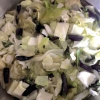 Cabbage and beans added to the potatoes in the pan to make Oying Vegetable Stew