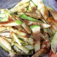 Spices and salt added to the green apples in the pan