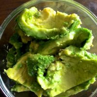 Cut through the avocado and scoop the flesh into a bowl. Add lemon juice