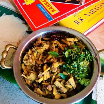 Bamboo shoot curry garnished with coriander leaves and a guide to Karnataka and a book by Mysore based author R K Narayanan alongside