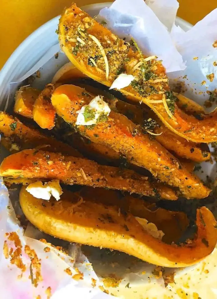 Baked squash liberally crusted with parmesan and herbs.