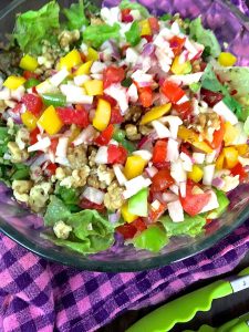 Colourful rainbow salad of fresh vegetables in a citrusy dressing