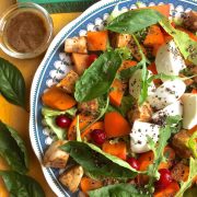 Autumn and Winter goodness of Persimmon and fresh mozzarella in a salad with mustard and balsamic vinegar and basil leaves on the side