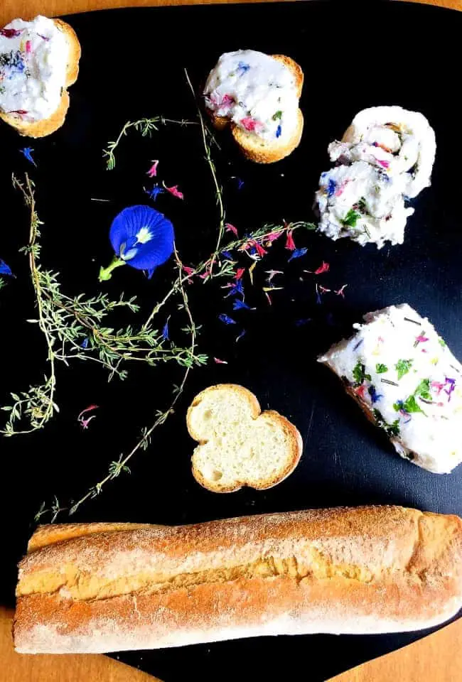 Rolled into a sausage shape and chilled this edible flower and herb butter can be cut into rounds and spread on crostini or bruschetta