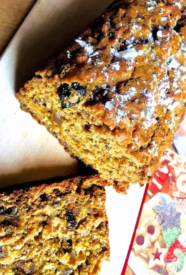 An eggless Christmas Fruit cake sliced and ready for serving. Studded with fruits that have been soaked before baking