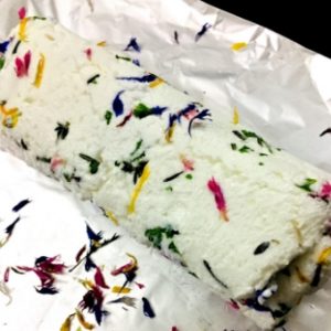 Step 3 in Edible Flower and herb butter. Roll the butter and tie up the ends of the cling wrap 