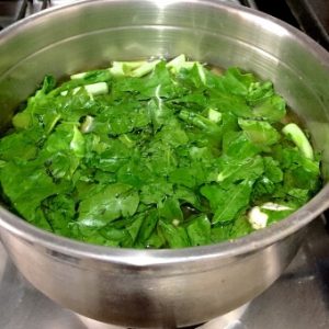 Add shredded cauliflower greens to the pan