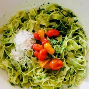 Top the Arugula pesto pasta with the cherry tomato sauce and grated parmesan