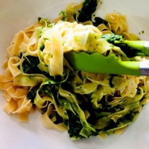 Making the pasta: the cooked fettuccine is tossed with the green arugula pesto