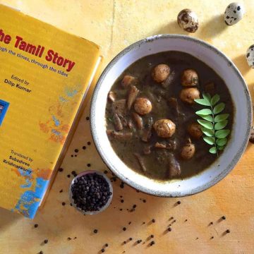 Kaada Muttai Milagu Kuzhambu: A white bowl with quail eggs in a pepper tamarind gravy. A yellow covered book with the name 'The Tamil Story' in Red, on the left and a bowl of pepper and scattered peppercorns in the foreground. A few speckled quail eggs in the background