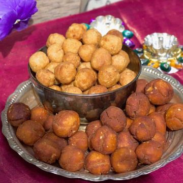 A plate of vella seedai from Store bought flour, with a bowl of smaller uppu seedai all on a pink silk fabric with a purple flower in the background and small silver lamps just behind the plate