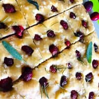 Sliced Savoury Cherry Focccia garnished with sage leaves.