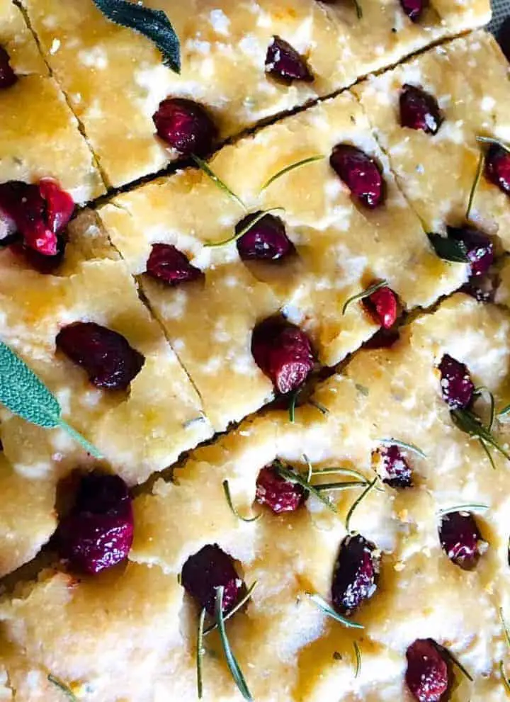 Sliced Savoury Cherry Focccia garnished with sage leaves.