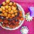 A plate of vella seedai from store bought flour and jaggery, with a bowl of lighter coloured uppu seedai above, on a dark pink silk fabric. Tiny colured sliver lamps and a purple flower to the right https://www.PepperOnPizza.com