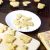 A batch of cream coloured simple animal shaped cookies on a wooden board and on a white plate