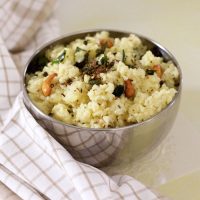 Bowl of well cooked rice and lentils. Hot savoury ven pongal tempered in ghee with cumin and pepper and garnished with cashew.