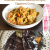 Two images: Top: A white bowl of yellow brown mashed cooked eggplant. Bottom: Two char roasted brinjal ready to peel, on a steel colander