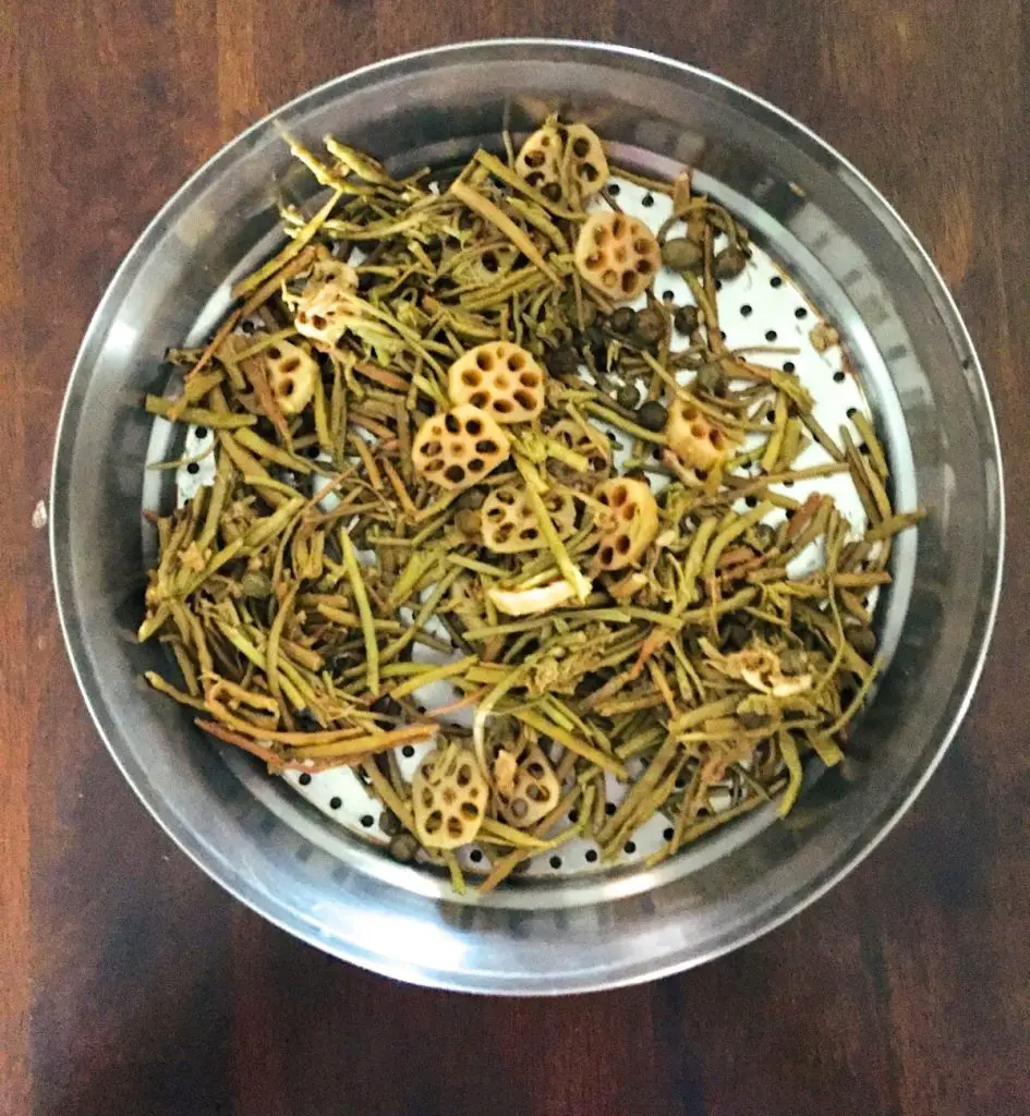 Dried ingredients for Rajasthani ker sangri sabzi soaked overnight and now drained in a steel colander along with slices of lotus root