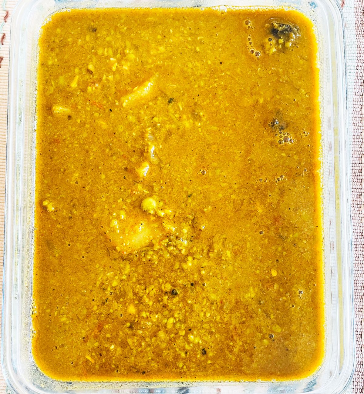 Brown yellow matar ka nimona with peas and potatoes in a recatangular glass serving bowl